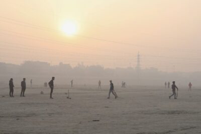 지난해 11월 대기오염으로 봉쇄령이 내려진 인도 뉴델리의 자무나강 둔치에서 주민들이 크리켓 경기를 하고 있다. /로이터 연합뉴스