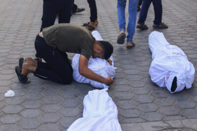 이스라엘군의 공습을 받고 사망한 팔레스타인들. 사망자의 가족이 시신에 애도를 표하고 있다. /AFP 연합뉴스